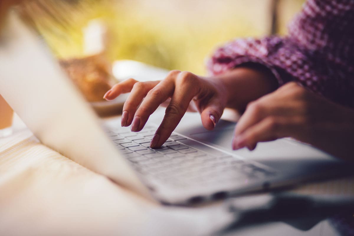 Person's hands typing content management mcallen words on a computer.